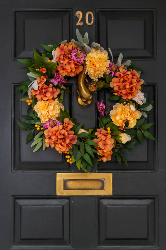 40 cm grapevine door wreath, yellow Peonies, burnt orange Hydrangeas, orange Wax Flower, pink Scabiosa, Ruscus & Lambs Ear. 