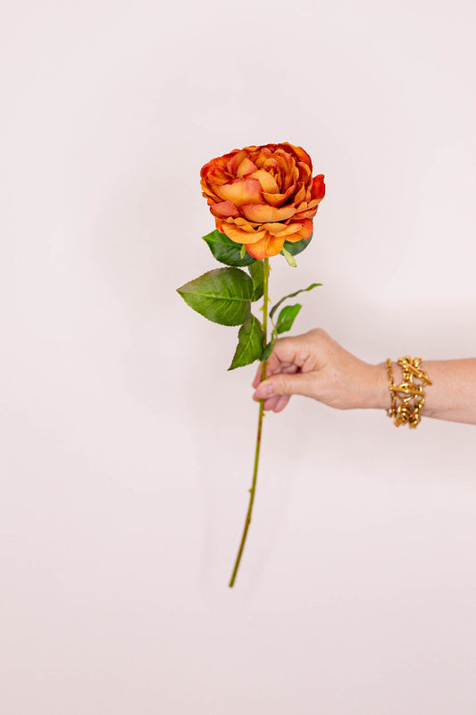a burnt orange artificial rose stem 