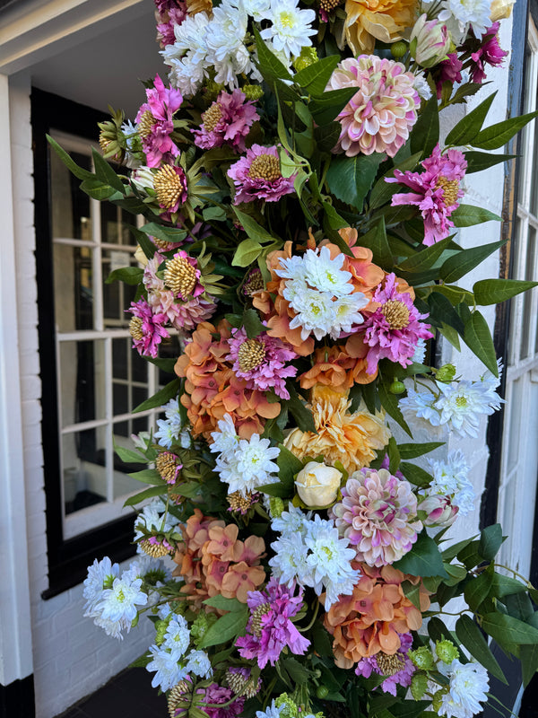 close up of the Floral installation at the doors of The Plough Inn Public House Southall with Hydrangeas, dahlias, scabiosa, chrysanthemums, ruscus, peonies.