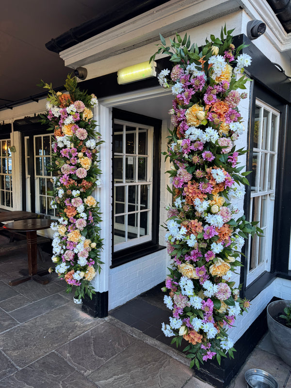 Floral installation at the doors of The Plough Inn Public House Southall with Hydrangeas, dahlias, scabiosa, chrysanthemums, ruscus, peonies.
